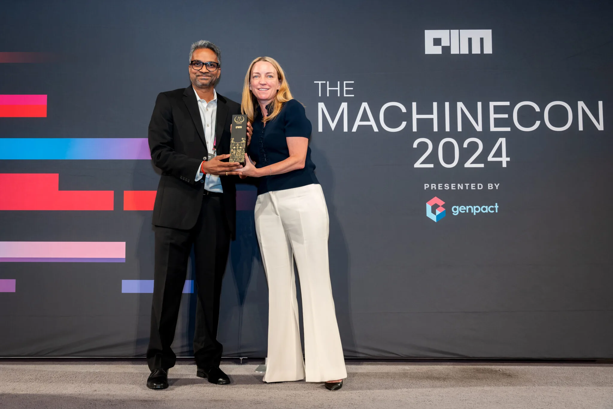Two recipients holding award at MachineCon New York 2024