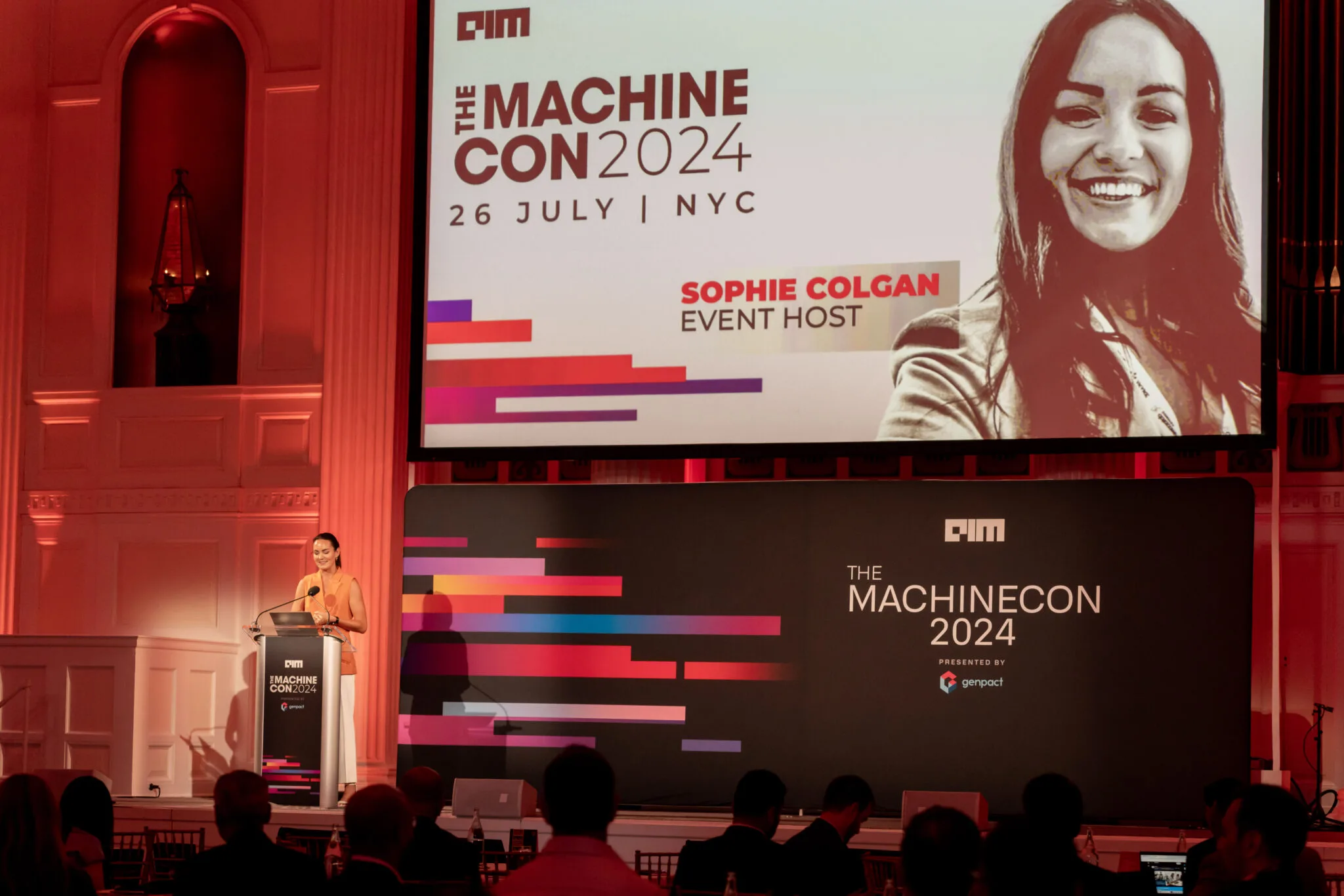 Event host speaking on stage at MachineCon New York 2024