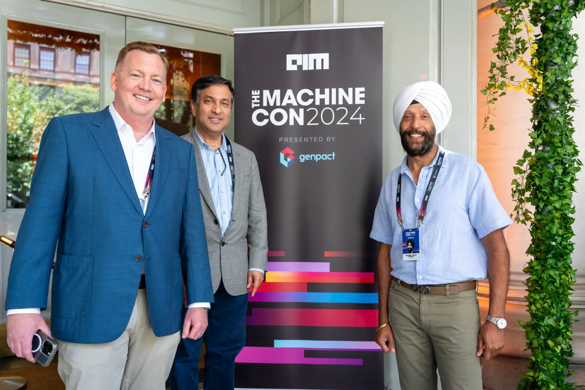 Attendees posing by event banner at MachineCon New York 2024