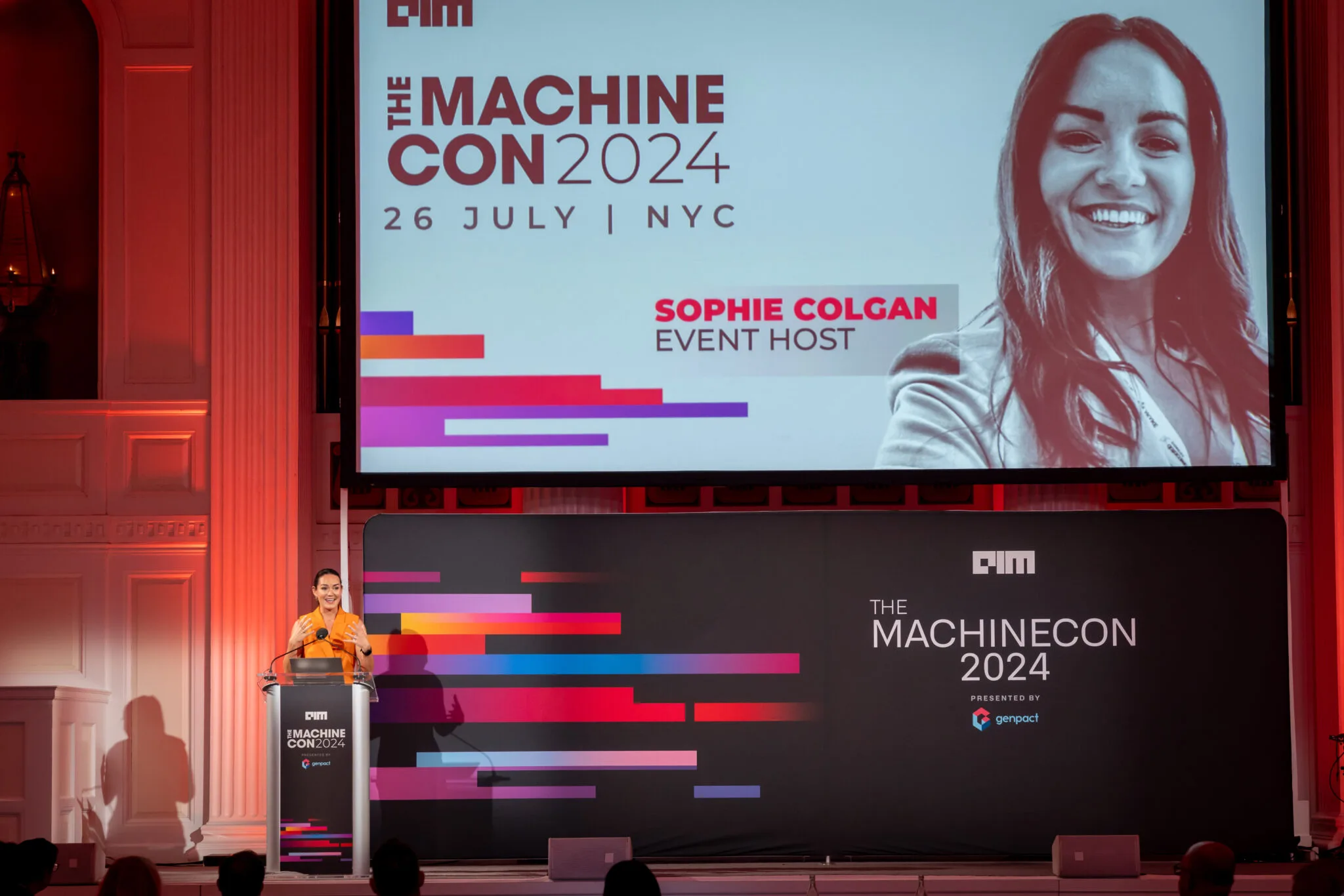 Event host speaking on stage at MachineCon New York 2024