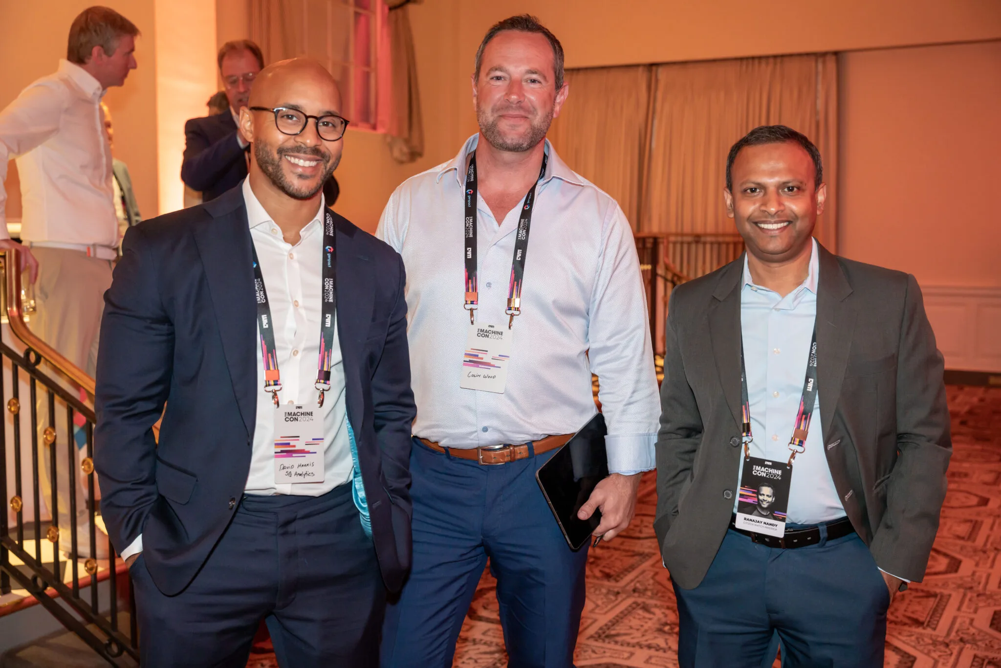 Three attendees posing and smiling at MachineCon New York 2024