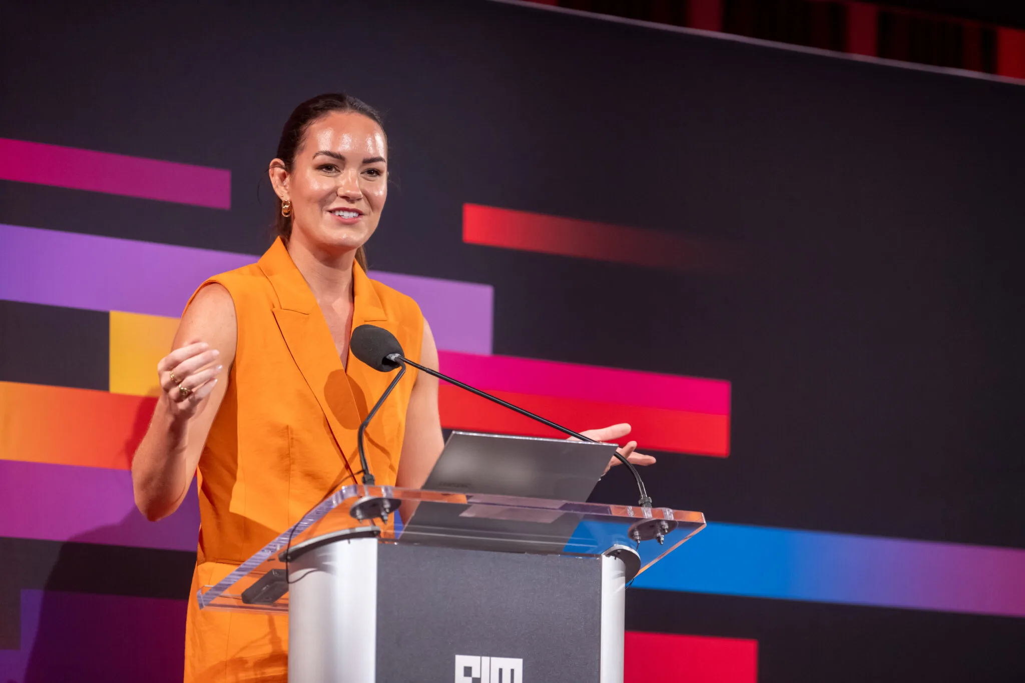 Speaker presenting at podium at MachineCon New York 2024