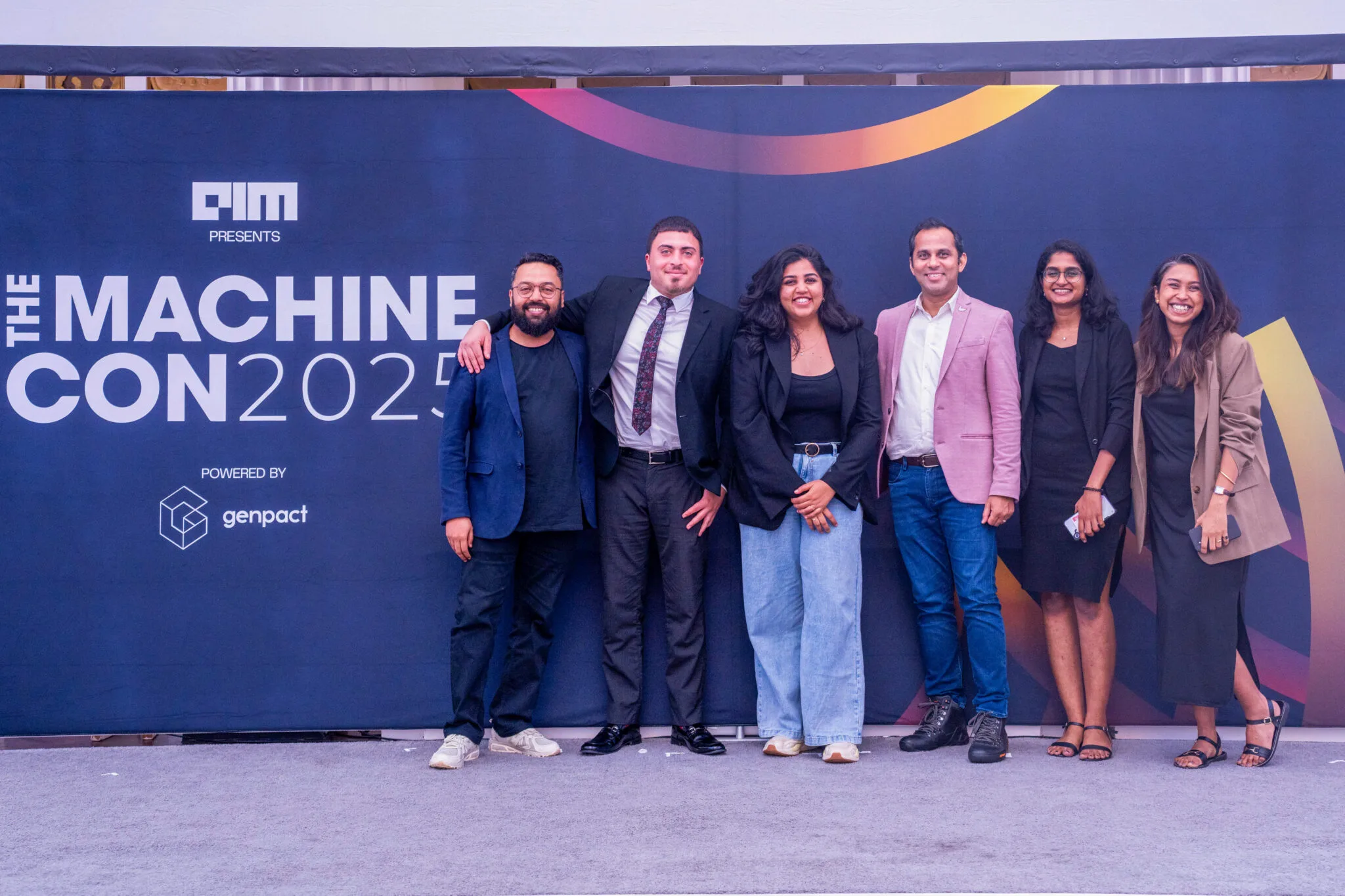 Group posing by event banner at MachineCon New York 2025