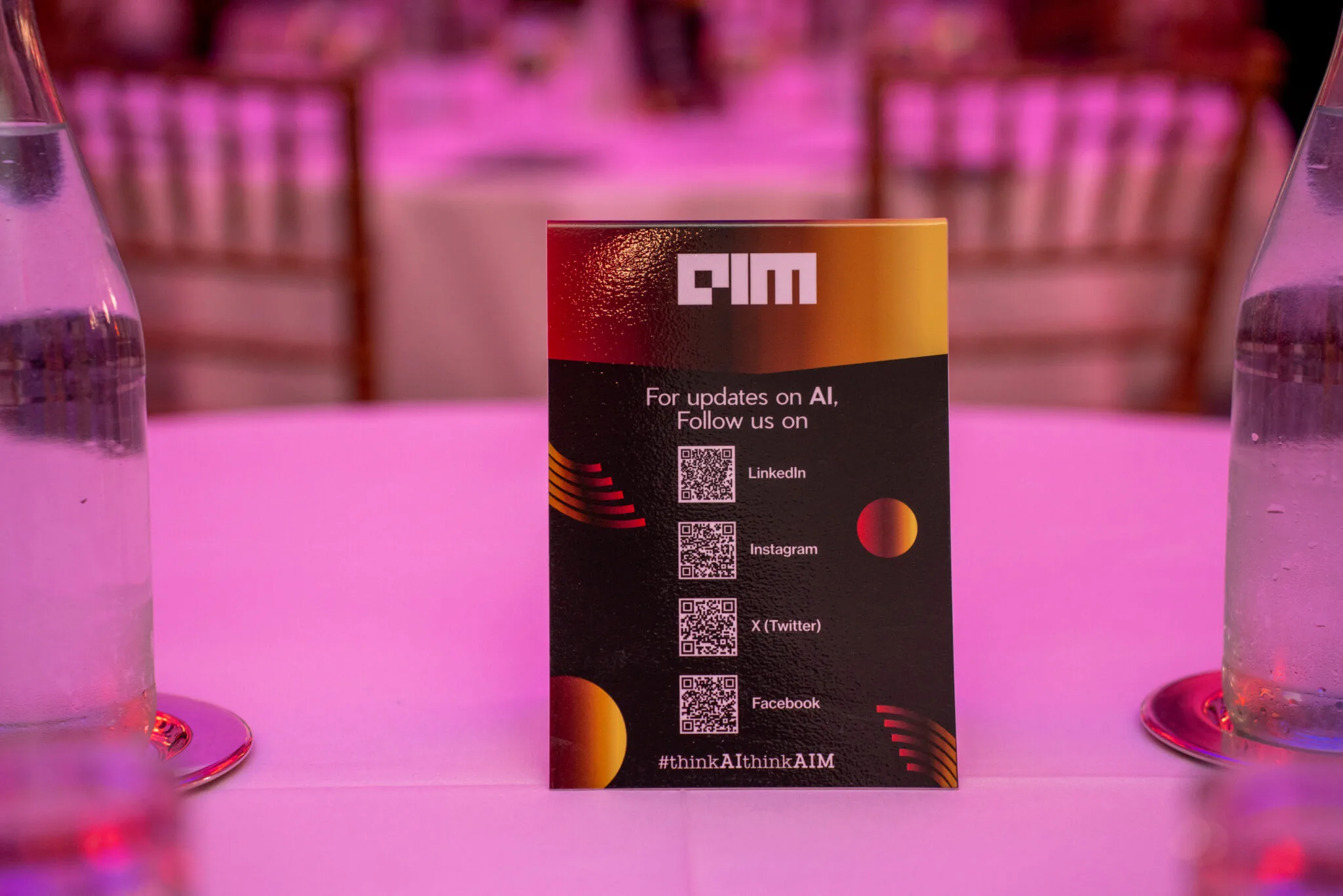 Table with AIM social media card at MachineCon New York 2025
