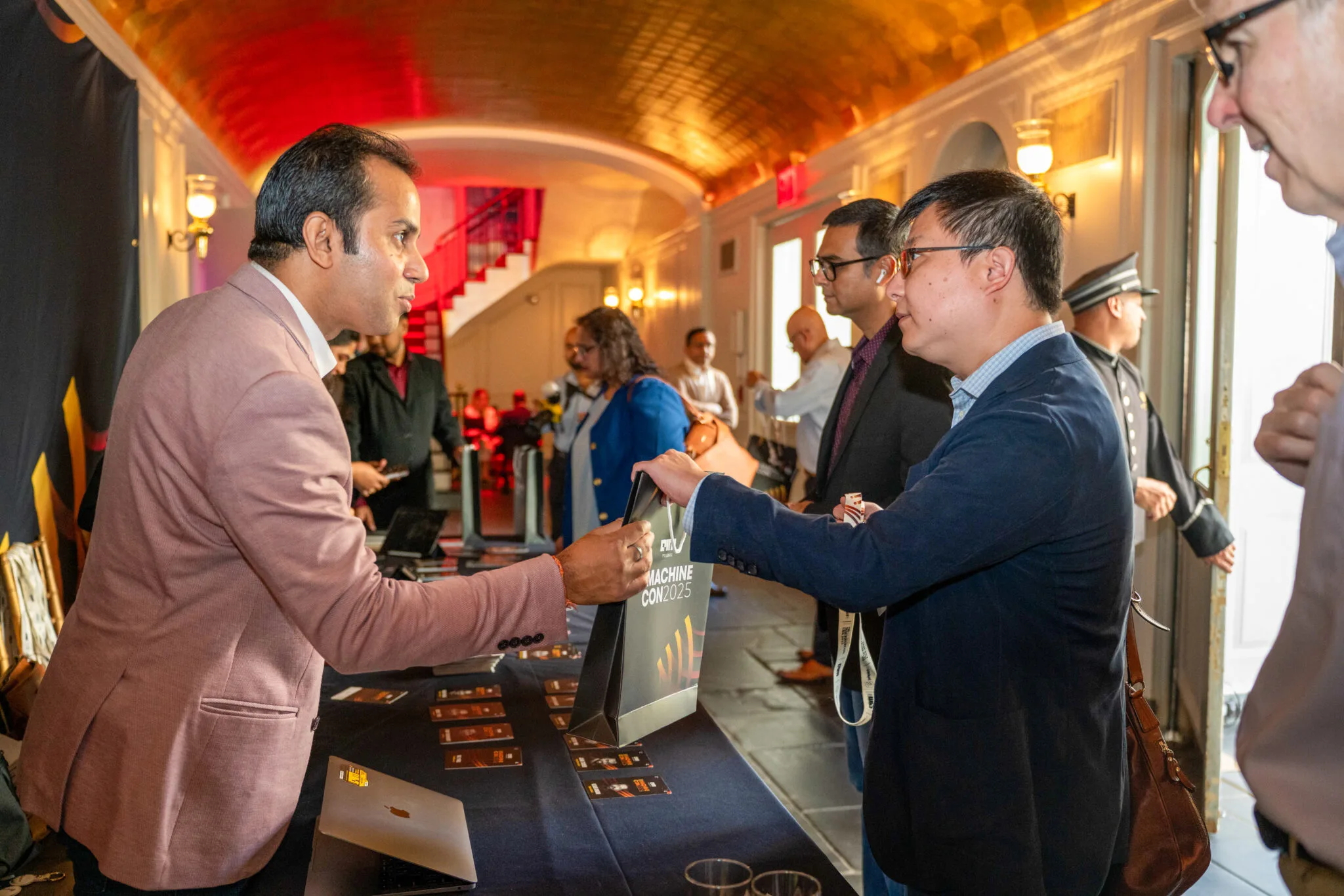 Exchanging conference materials at MachineCon New York 2025
