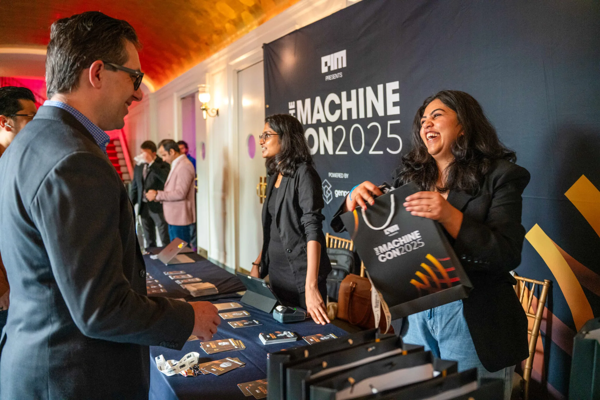 Attendees chatting at registration desk at MachineCon New York 2025