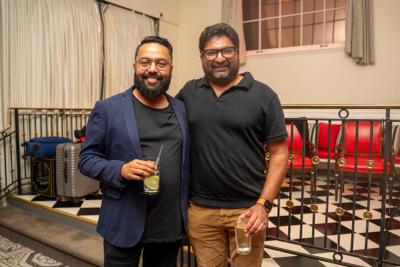 Two men smiling with drinks · 2025
